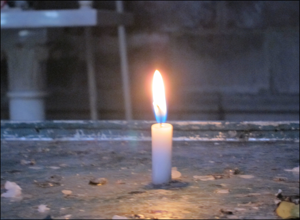 A single candle in La Basilica de Quito in Quito, Ecuador